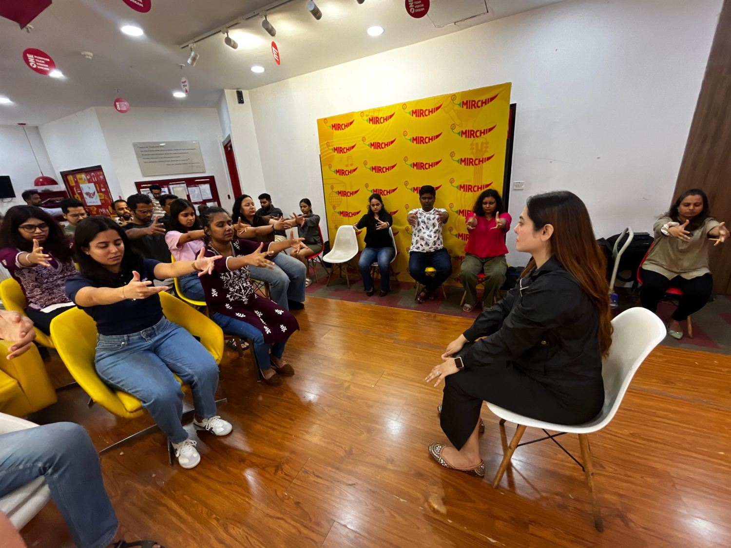 A group hypnotherapy session in progress with participants seated and following a guided exercise
